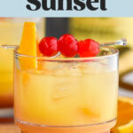 glass of tequila sunset with ice and cherry and orange slice garnish