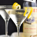 two glasses of Vesper Martini with lemon twist garnish and bottle of Lillet blanc in the background