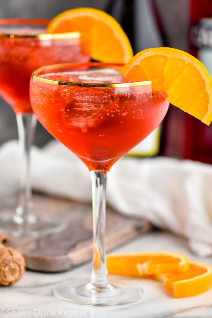 two glasses of Campari Spritz with ice and orange slice garnish