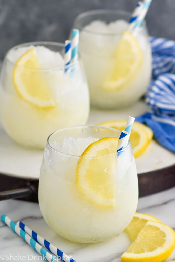 three glasses of Frozen Lemonade with straws and lemon slice garnish