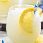 glass of frozen lemonade with a straw and lemon slice garnish