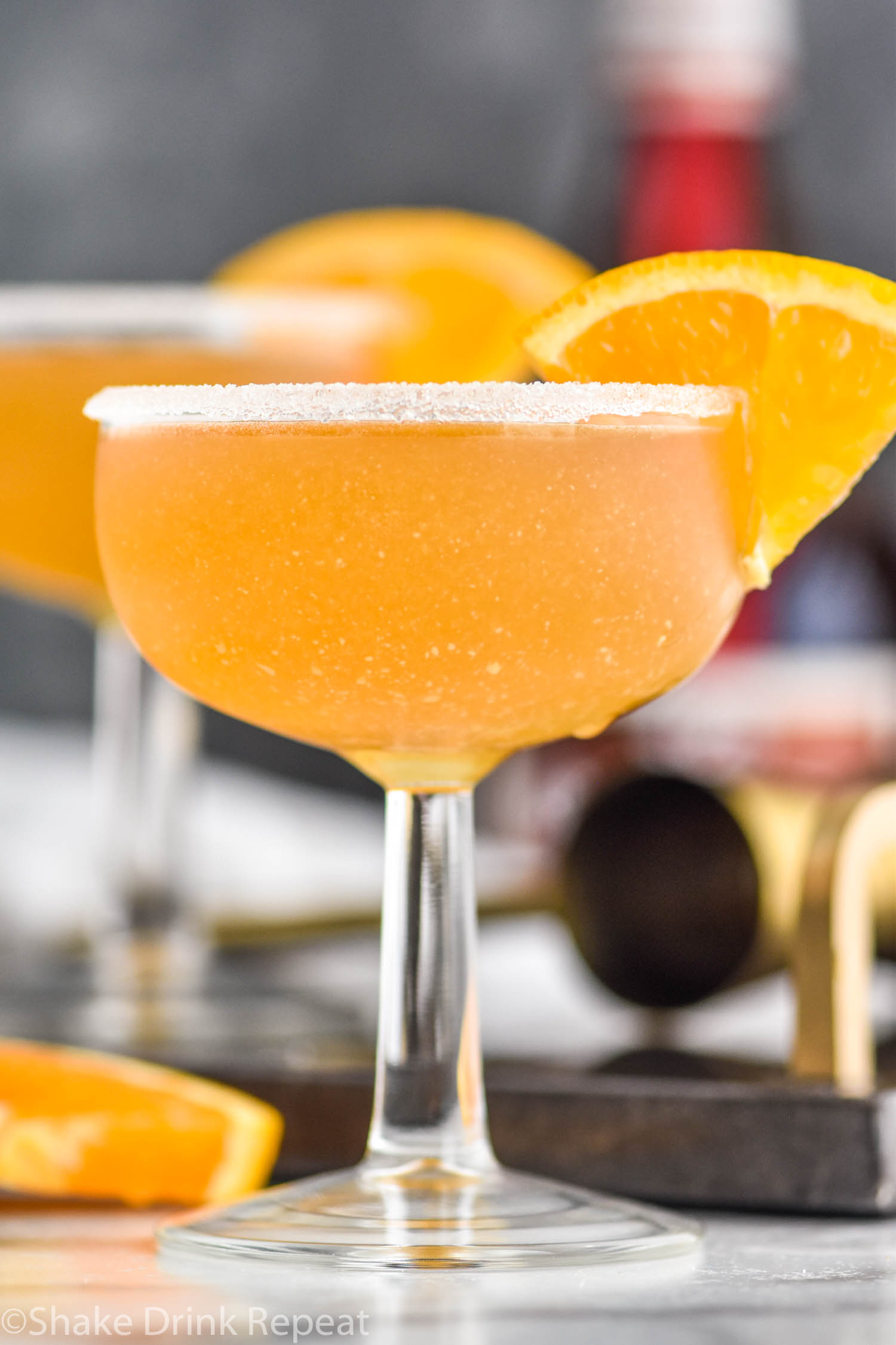 glass of Sidecar cocktail with sugared rim and orange slice