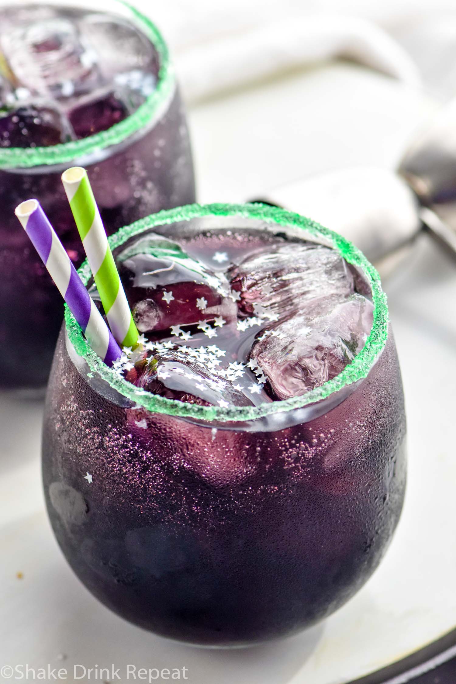 two glasses of Drunk Witch cocktail with ice and straws
