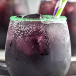 rimmed glass of Drunk Witch cocktail with ice and straws