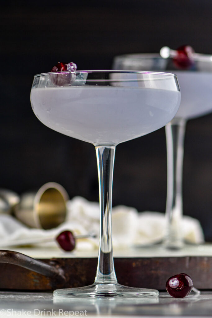 two glasses of Aviation cocktail garnished with a cherry