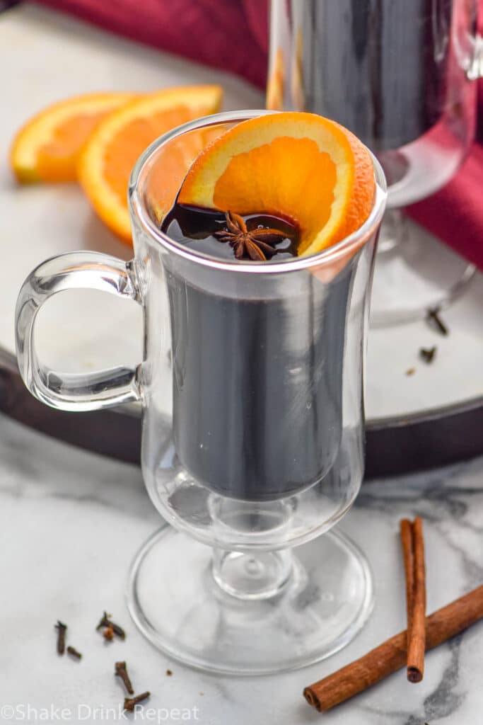 two mugs of Mulled Wine with orange slices, clove and cinnamon sticks