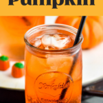 glass of Drunk Pumpkin cocktail recipe with ice, straw and surrounded by pumpkin candies