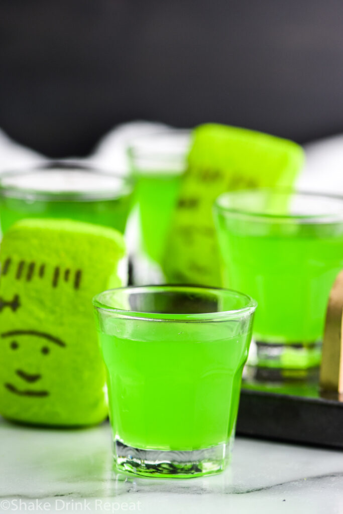 shot glasses of Frankenstein Shot with green peep garnish