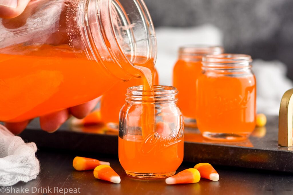 candy corn vodka being poured into a small shot glass