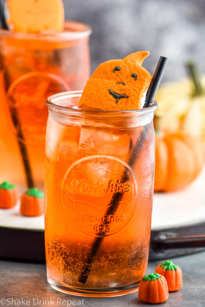 two glasses of Drunk Pumpkin cocktail recipe with ice, straw, and garnished with pumpkin peep candy