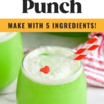 glass of Grinch Punch recipe with two straws and a candy heart garnish