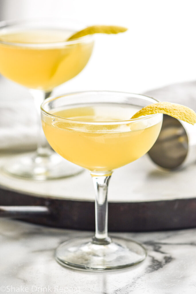 two coupe glasses of Between the Sheets cocktail recipe with lemon peel garnish