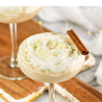 glass of Cinnamon Roll Martini topped with whipped cream and cinnamon sticks