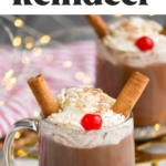 two mugs of Drunk Reindeer recipe garnished with whipped cream, cinnamon sticks, a cherry, and chocolate shavings