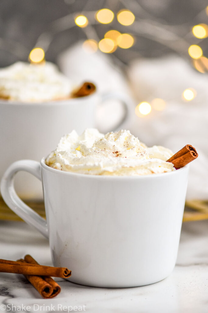 mug of Spiked Eggnog Latte topped with whipped cream and a cinnamon stick