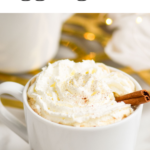 mug of Spiked Eggnog Latte topped with whipped cream and a cinnamon stick