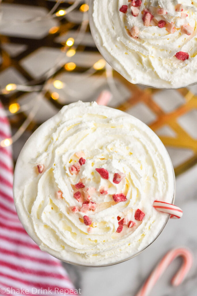 two glasses of Candy Cane Martini recipe topped with whipped cream and crushed candy canes