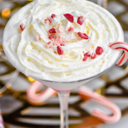glass of Candy Cane Martini recipe topped with whipped cream and crushed candy canes