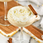 two glasses of Cinnamon Roll Martini garnished with whipped cream and cinnamon sticks