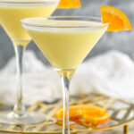 two martini glasses of Golden Dream recipe garnished with an orange slice