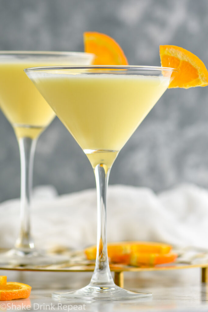 two martini glasses of Golden Dream recipe garnished with an orange slice