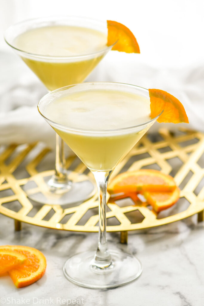 two martini glasses of Golden Dream recipe garnished with orange slice