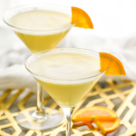 two martini glasses of Golden Dream recipe garnished with orange slice