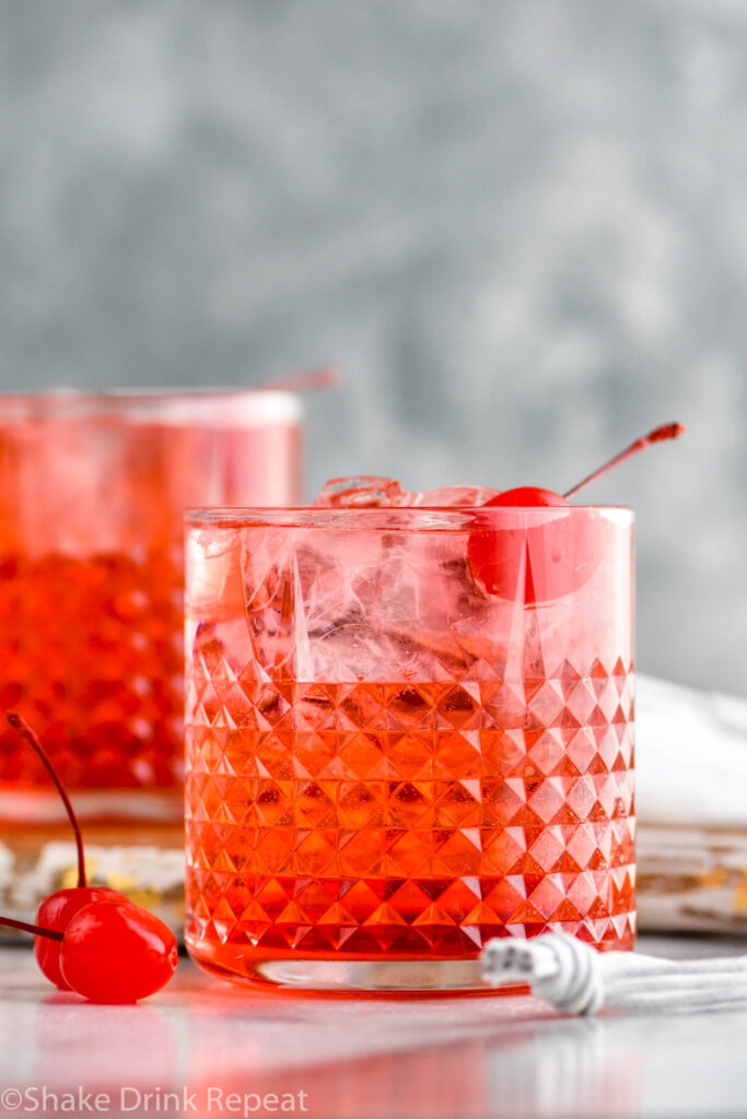 Two glasses of Dirty Shirley drinks with ice and maraschino cherries