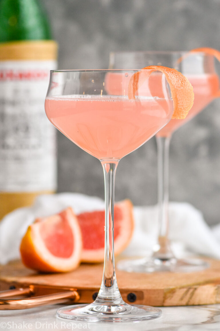 Two glasses of Hemingway Daiquiri recipe garnished with grapefruit twist with bottle of Luxardo in the background