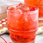 close up of two glasses of Shirley Temple drink with ice and garnished with maraschino cherries