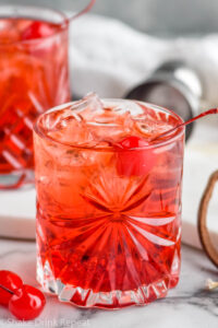 two glasses of Shirley Temple Black with ice and maraschino cherries