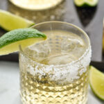 Two glasses of Tequila and Ginger Ale with ice, salted rim and wedge of lime for garnish