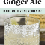 man's hand pouring can of ginger ale into a glass of ice and tequila with salted rim to make a tequila and ginger ale cocktail