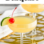 two glasses of Banana Daiquiri garnished with a slice of lime and cherry