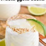 Glass of Coconut Margarita with ice and toasted coconut rim with garnished with lime wedge