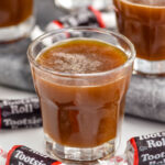 Shot glasses of Tootsie Roll Shot recipe surrounded by Tootsie Roll candies