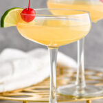 two glasses of Banana Daiquiri garnished with a slice of lime and cherry