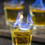 three shot glasses of Flaming Dr. Pepper ingredients on fire