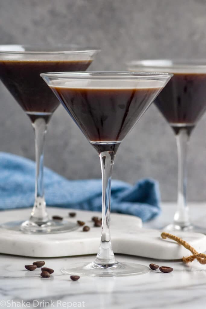 three martini glasses of Espresso Martini garnished with espresso beans