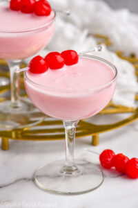 two coupe classes of Pink Squirrel cocktails garnished with three cherries