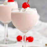 two glasses of Pink Squirrel with Ice Cream garnished with whipped cream and a cherry