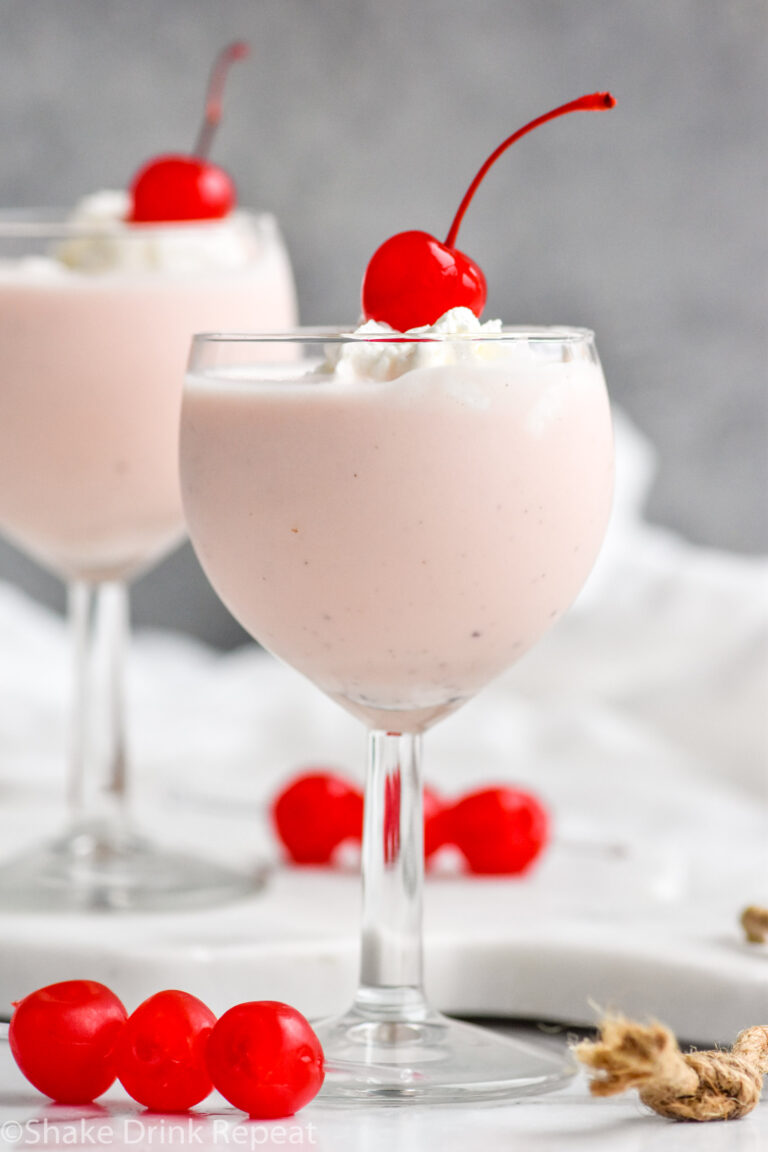 two glasses of Pink Squirrel with Ice Cream garnished with whipped cream and a cherry