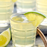 shot glass of green tea shot garnished with a lime wedge