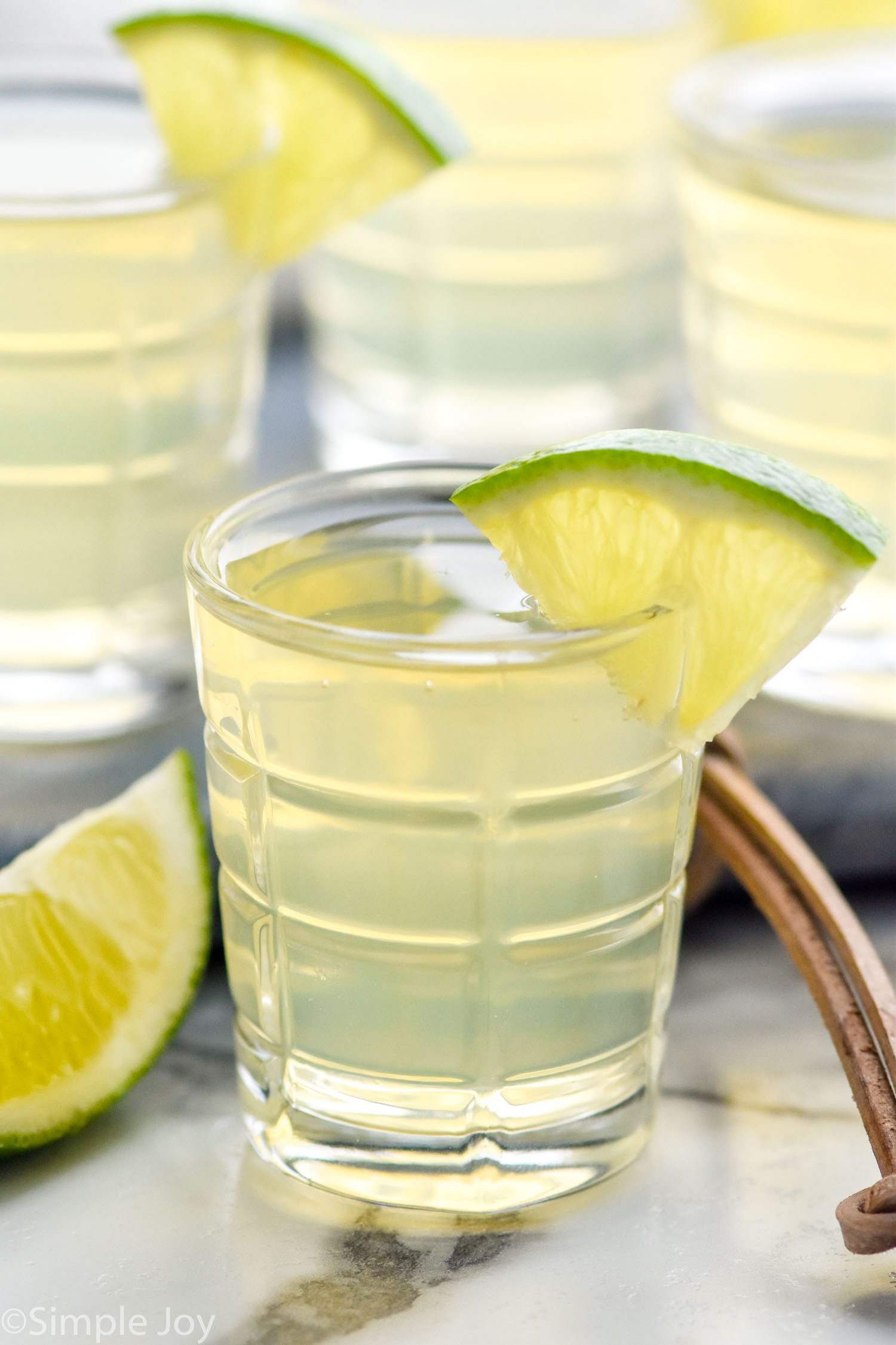 shot glass of green tea shot garnished with a lime wedge