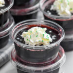 Overhead photo of Drunk Witch Jell-O Shots garnished with whipped cream and sprinkles.