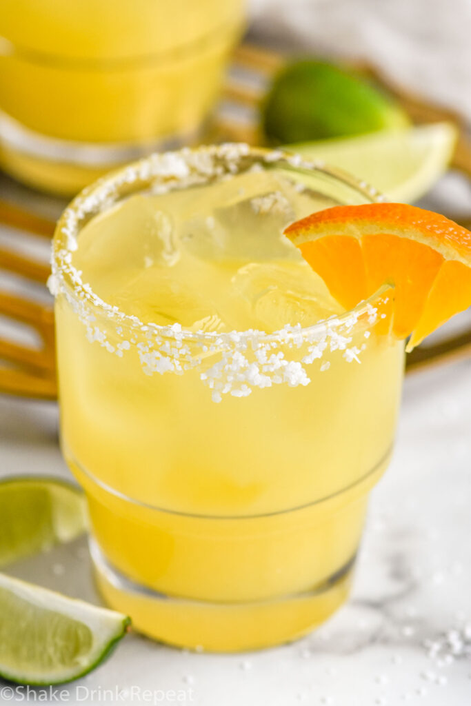 Overhead photo of Italian Margarita recipe served in a glass with a salted rim and garnished with an orange slice.