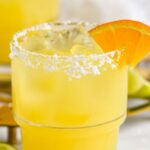 Pinterest graphic for Italian Margarita recipe. Text says, "Italian Margarita shakedrinkrepeat.com." Image is photo of Italian Margarita served in a glass of ice with a salted rim, garnished with an orange slice.