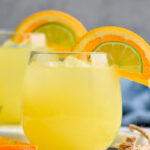 Photo of Texas Margarita recipe served in two glasses, each garnished with an orange slice and a lime wedge.