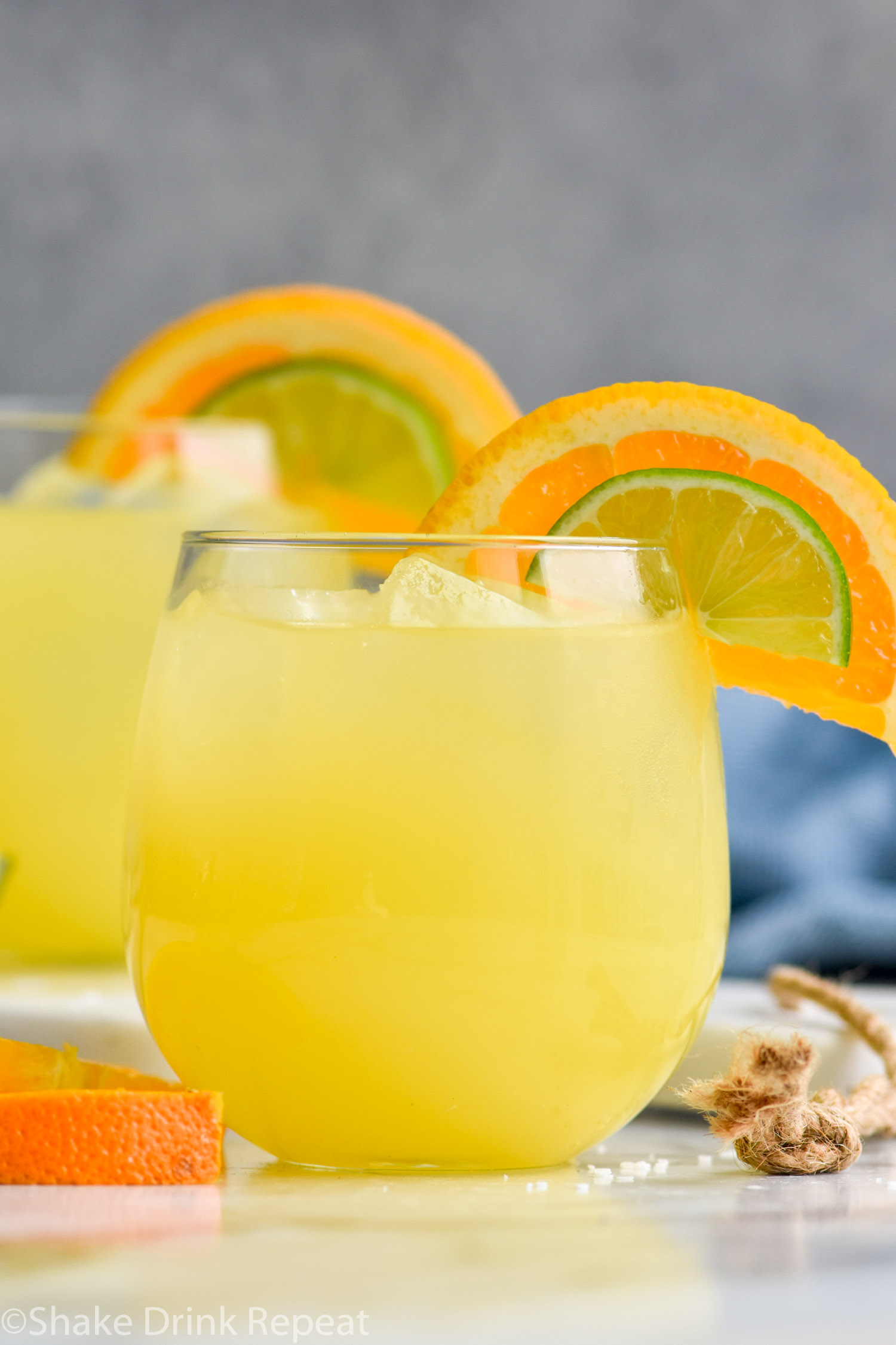 Photo of Texas Margarita recipe served in two glasses, each garnished with an orange slice and a lime wedge.