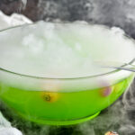 punch bowl of Halloween Punch with smokey dry ice, ladle and eye ball garnish